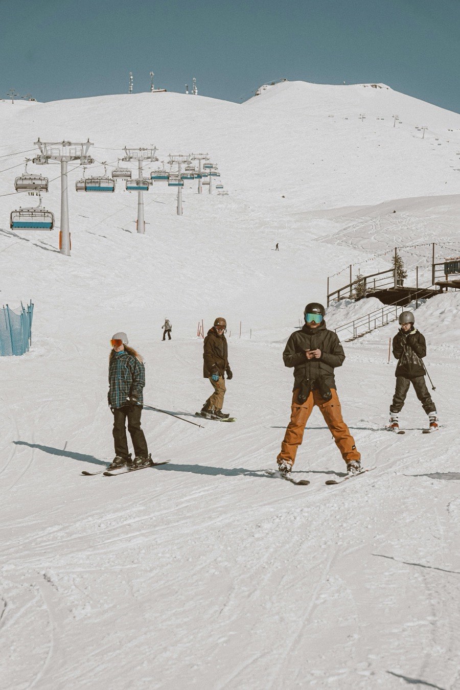 Skiers heading down a run beneath the chairlift